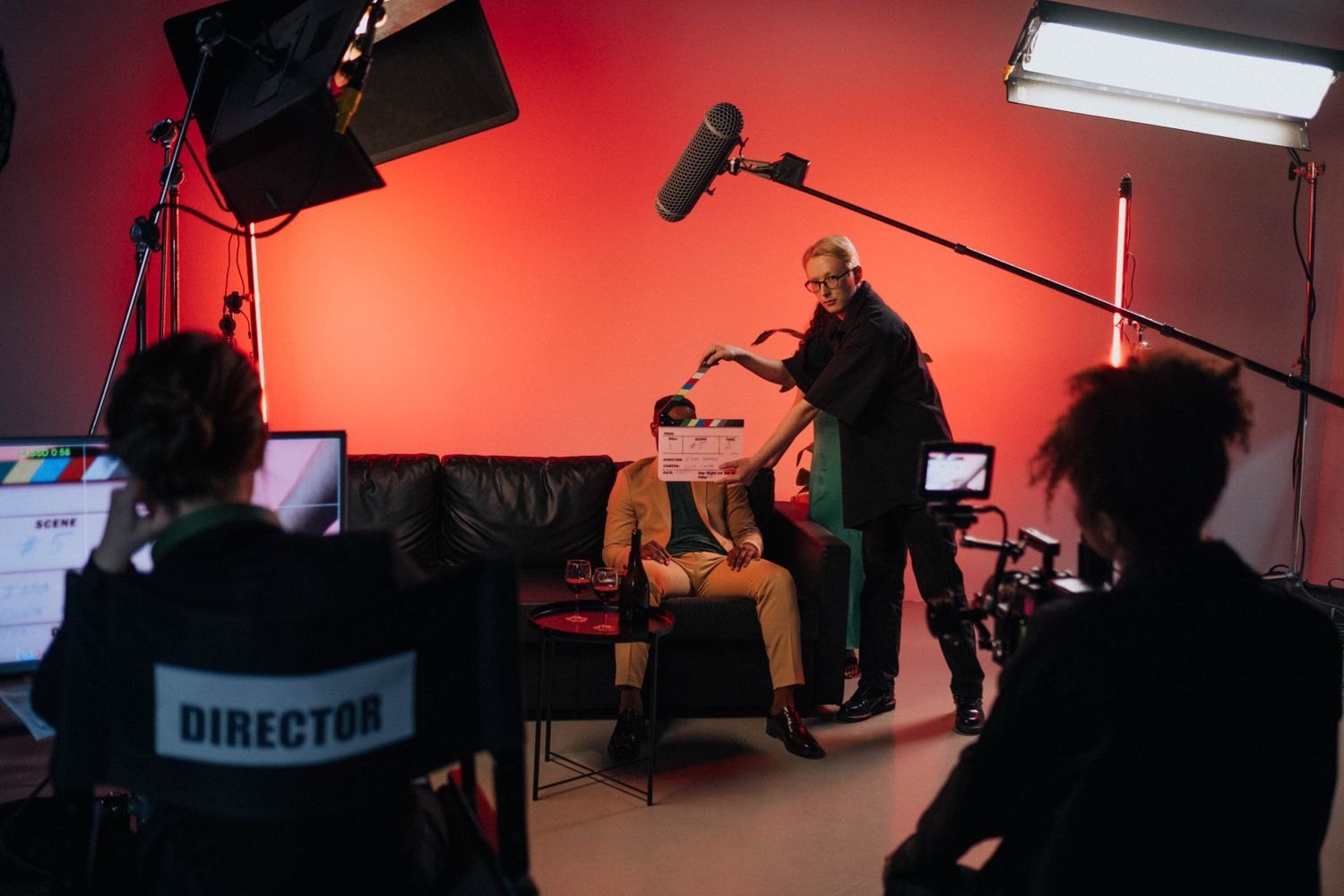 A film crew with a camera, lights and clapperboard on set.