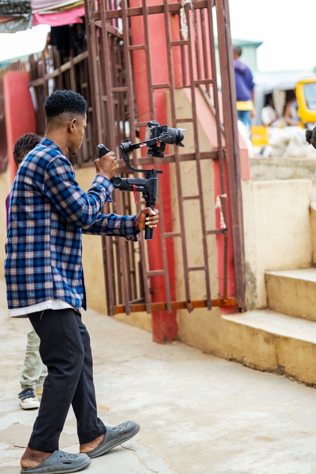 A camera operator using a stabiliser on a street.
