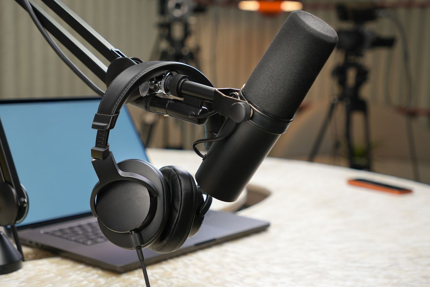 A podcast microphone and headphones at a recording station.